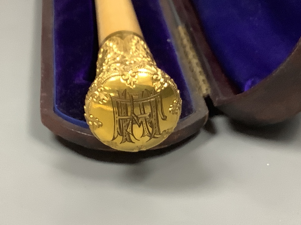 A yellow metal mounted conductor's baton, with monogram to handle base, in fitted case